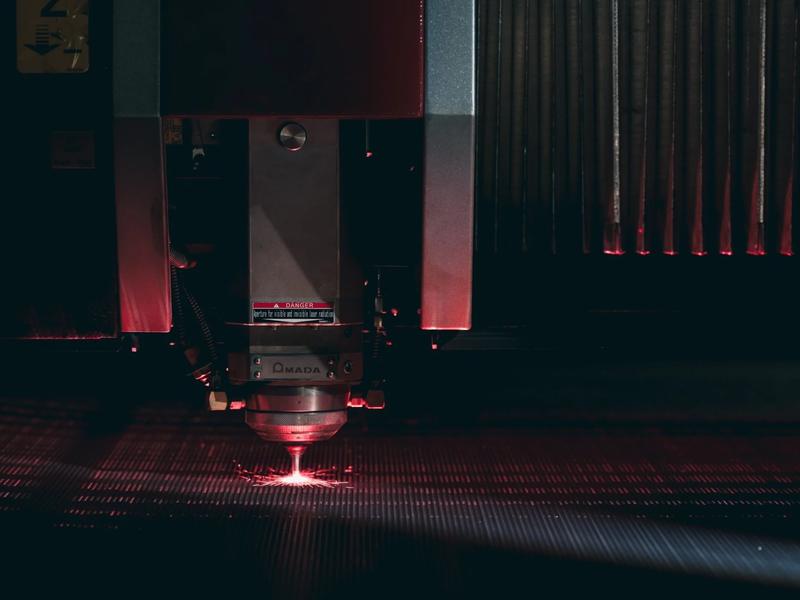 Amada laser head cutting inside the machine enclosure