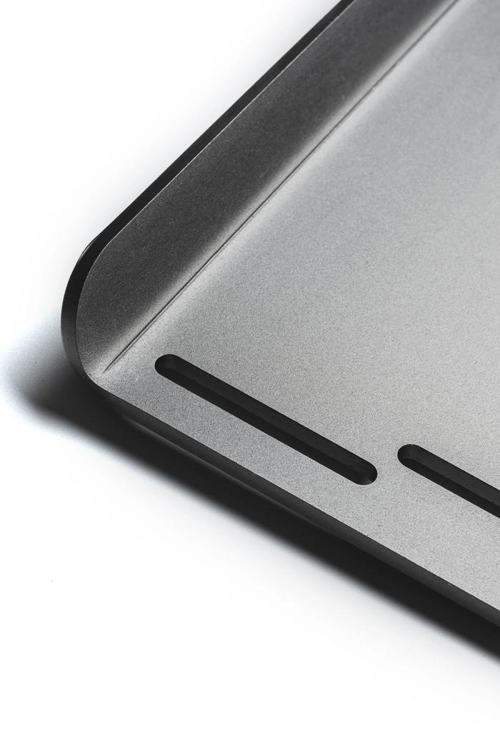 A finished steel part with laser-cut slots and a formed radius edge